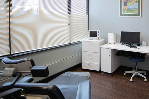 The image shows an office setting with dental equipment visible, including chairs and a computer desk with a monitor, keyboard, and mouse.